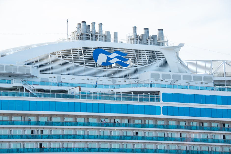 Detailed view of a modern cruise ship's upper deck with visible cabins and chimneys.