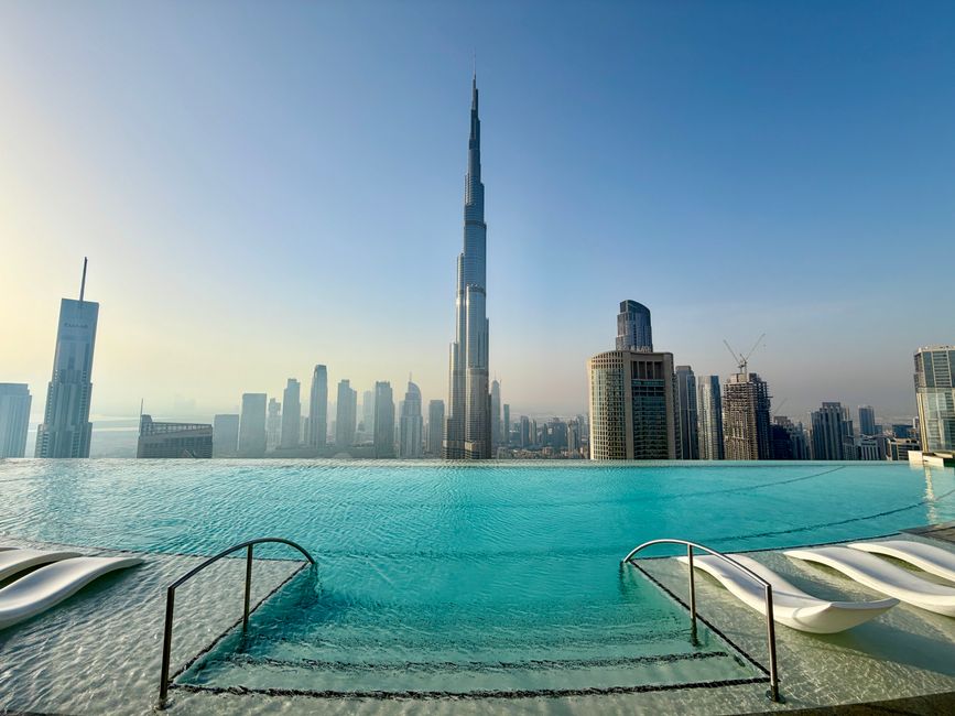 Infinity pool overlooking the Burj Khalifa and Dubai skyline at sunrise, capturing modern architecture.