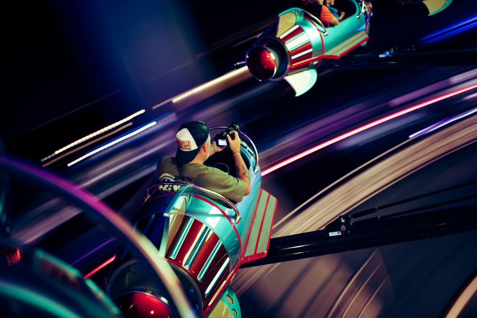 An exhilarating motion-capture of a spinning amusement park ride at night, full of vibrant lights and energy.