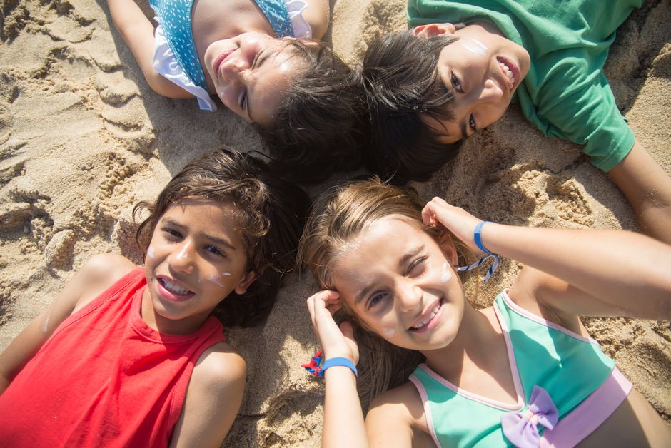 Group of diverse children having fun on a sandy beach in summer.