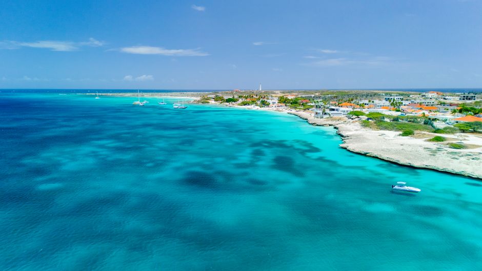 A breathtaking aerial view of Aruba's coastline featuring turquoise waters and a clear blue sky.