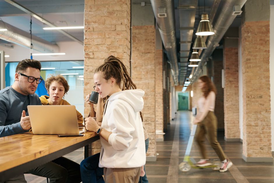 A team of young professionals engaging in a collaborative discussion in a trendy, open office environment.
