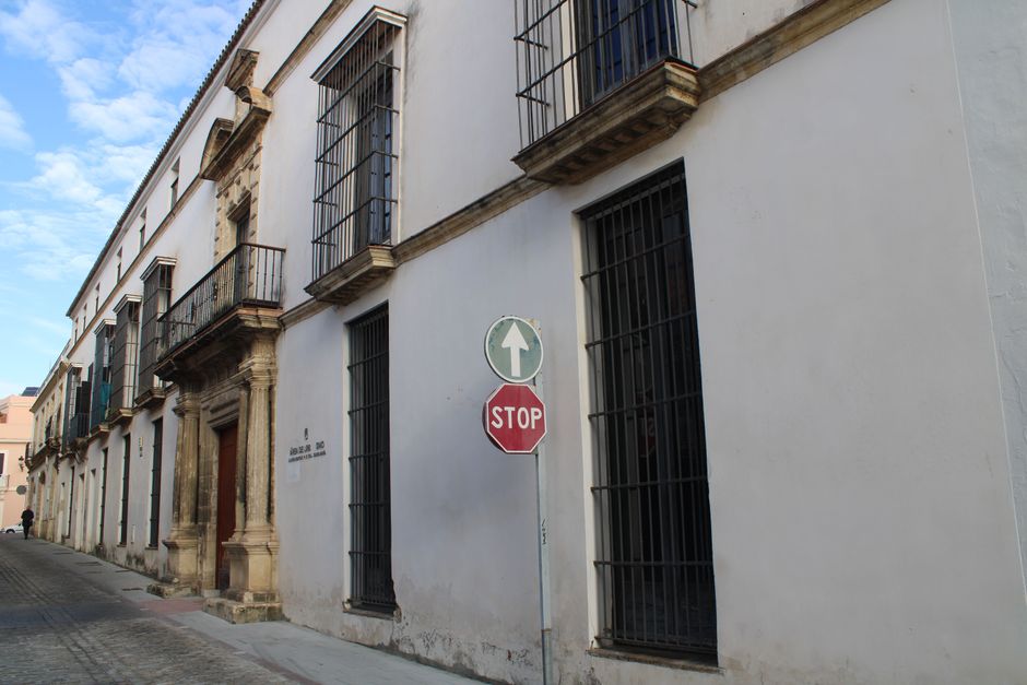Charming street view with historic buildings and a stop sign in Andalucía, Spain.