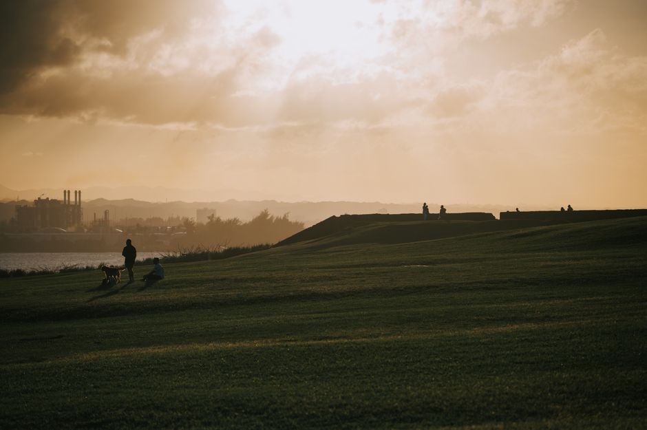 Captivating golden hour skyline in San Juan, Puerto Rico with silhouettes and lush greenery.