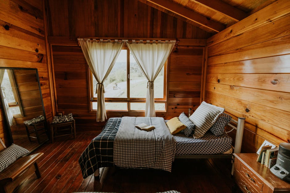 Warm and inviting wooden cabin bedroom featuring a scenic outdoor view with natural light.