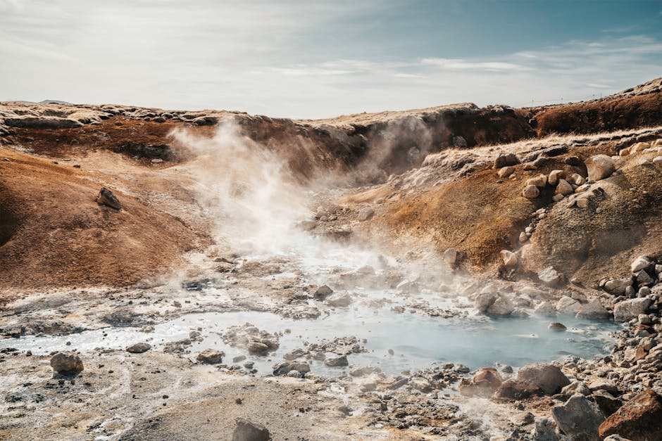 Iceland's steaming geothermal area showcasing rugged terrain and vibrant colors.