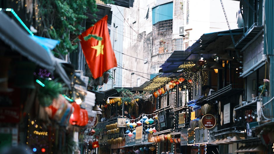 Lively street with flags and lanterns in an Asian urban setting.